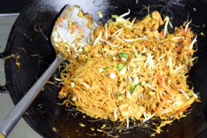 Singapore noodles frying in wok